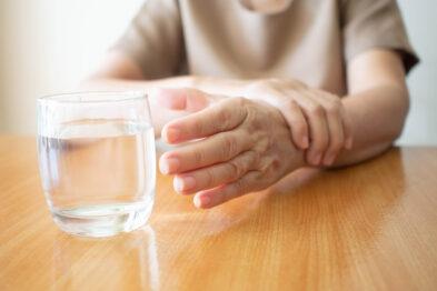 shaking hand reaching for glass, indicating Parkinson's