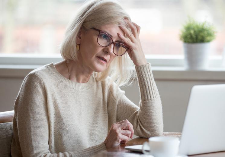 woman with memory issues looking confused at laptop