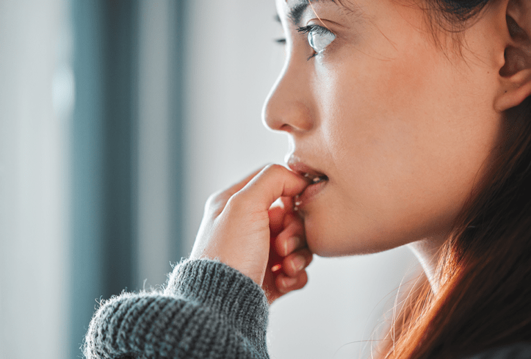 woman with anxiety biting her fingernails